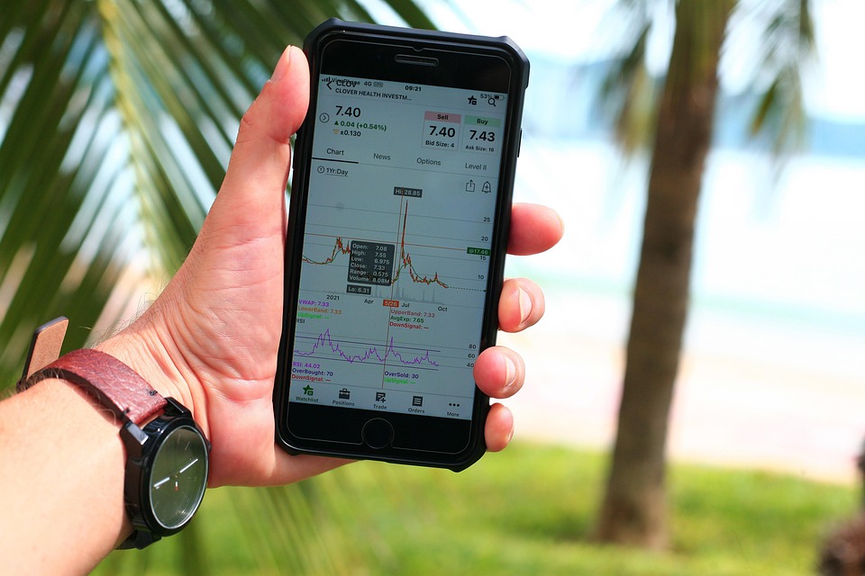 Should you invest in Roth IRA A person holding a phone and stock market graph is showing on phone