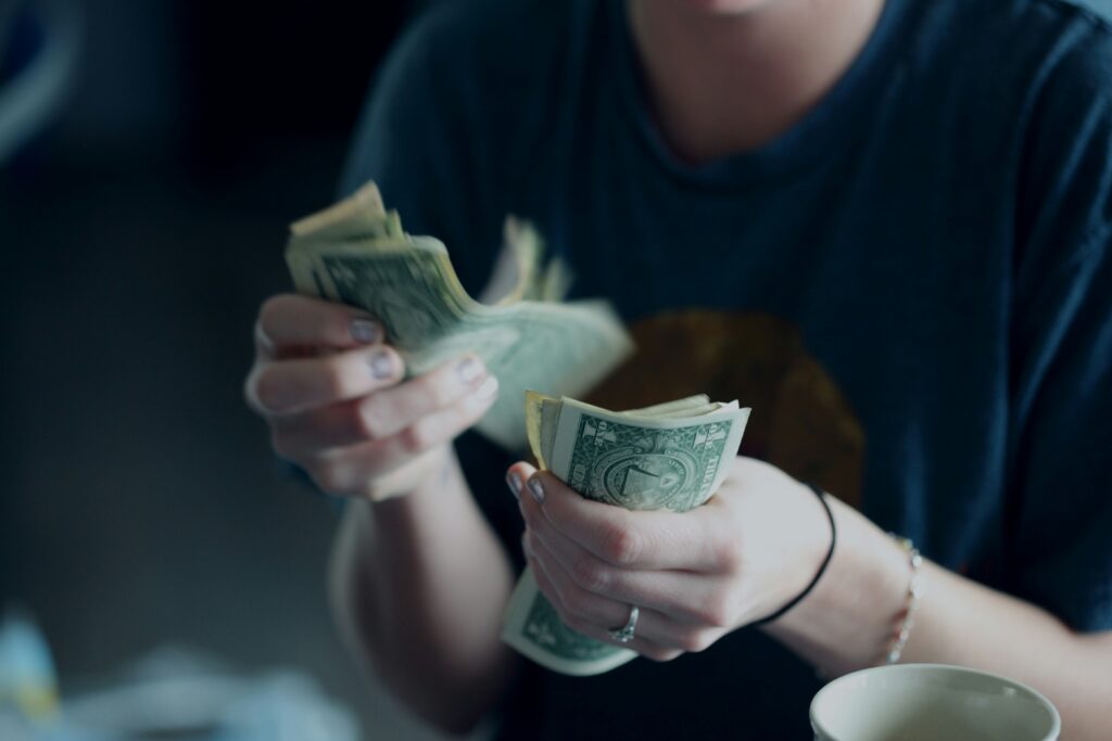 A girl is counting cash by her hand 