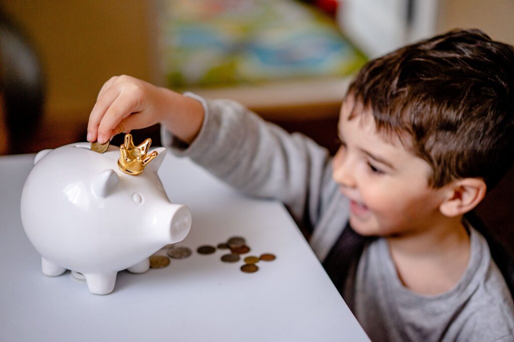 A child putting coin inside the piggy bank